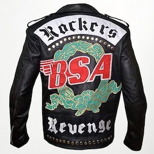 Könnte beinhalten: Schwarze Lederjacke mit "Rockers" über den Schultern und "BSA Revenge" auf dem unteren Rücken. Der Rücken zeigt ein rot-weißes "BSA"-Logo mit einem grünen Kranzdesign. Die Jacke hat einen klassischen Biker-Stil mit einem Reverskragen.