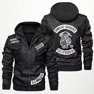 Könnte beinhalten: Schwarze Lederjacke mit Kapuze und mehreren Aufnähern. Die Jacke trägt die Aufschrift "PRESIDENT MEN OF MAYHEM", "REDWOOD ORIGINAL" und "SAMCRO". Auf dem Rücken der Jacke befindet sich eine Grafik mit den Worten "SONS OF ANARCHY", einem Totenkopf und "CALIFORNIA".