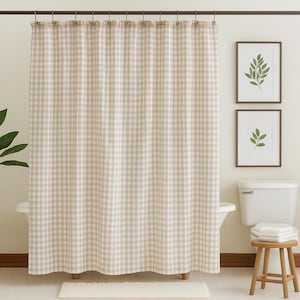 Peut inclure: Rideau de douche à carreaux beiges et blancs dans une salle de bain. Le rideau présente un motif vichy classique et est fait d'un tissu doux. Il est suspendu à une tringle en métal foncé avec des anneaux assortis.