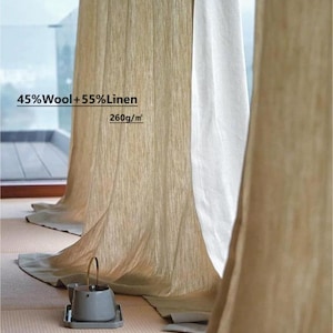 May include: Beige linen curtains with a soft, textured appearance hang near a white curtain. The curtains are labeled as 45% wool and 55% linen, with a density of 260g/m². A small gray teapot sits on a tray on the floor.