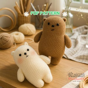 May include: Two crocheted bear plushies. One is light brown, the other is white with pink cheeks. The bears have black eyes and small arms and legs. The words "PDF PATTERN" are in green with white flower accents.