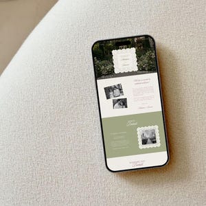 Peut inclure: Un smartphone affichant un mod&egrave;le d'invitation de mariage num&eacute;rique avec un fond blanc, des accents vert sauge et des cadres festonn&eacute;s orn&eacute;s. L'&eacute;cran pr&eacute;sente du texte incluant "Wedding Day Details", "Venue Details" et "St. Mary's Church", ainsi que des photos en noir et blanc.