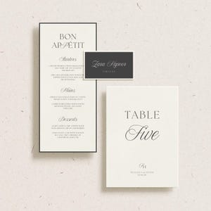 Może przedstawiać: Elegancki zestaw papeterii ślubnej z menu, wizyt&oacute;wką i numerem stołu. Menu zawiera napis "Bon App&eacute;tit" i wymienia przystawki, dania gł&oacute;wne i desery. Wizyt&oacute;wka wyświetla "Zara Kapoor". Karta z numerem stołu m&oacute;wi "Table Five".