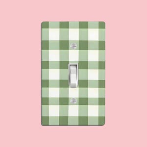 Puede incluir: Una cubierta de interruptor de luz con un patrón de cuadros verdes y blancos. El interruptor está etiquetado como "OFF".