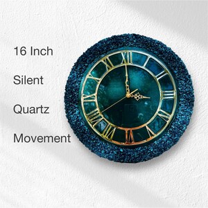 K&ouml;nnte beinhalten: Eine 16-Zoll-Wanduhr mit einem runden, texturierten Rand aus dunkelblaugr&uuml;nem Schotter. Das Zifferblatt hat einen dunkelblaugr&uuml;nen Hintergrund mit goldenen r&ouml;mischen Ziffern und goldenen Zeigern. Der Text links lautet 16 Inch Silent Quartz Movement.