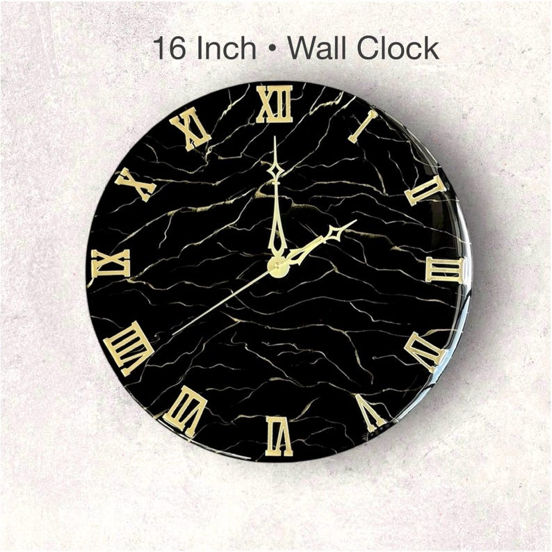 May include: A 16-inch wall clock with a black marble design and gold Roman numerals. The clock hands are gold, and the face has a glossy finish. The text "16 Inch &bull; Wall Clock" is at the top.