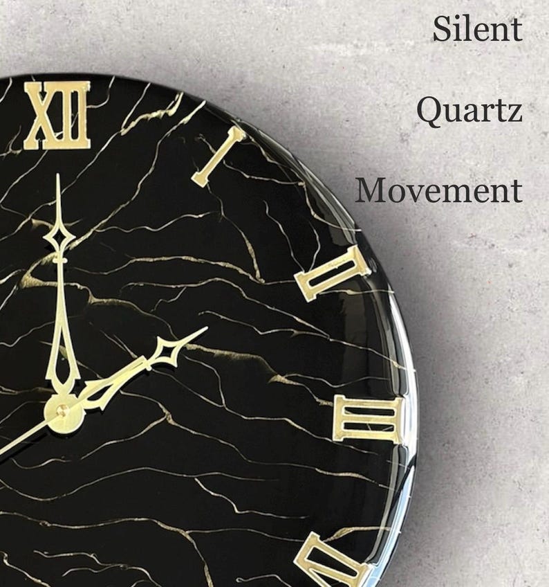 May include: A black and gold marble-patterned wall clock with gold Roman numerals and hands. The clock face features the words "Silent Quartz Movement". The clock is a decorative item for home decor.