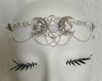 May include: Silver triple moon headpiece with a white opal gemstone and beaded chain accents.