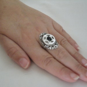 Puede incluir: Un anillo de plata con una piedra negra engastada en un dise&ntilde;o decorativo.