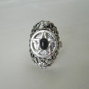 Puede incluir: Anillo de plata con una piedra negra engastada en un dise&ntilde;o de pentagrama.
