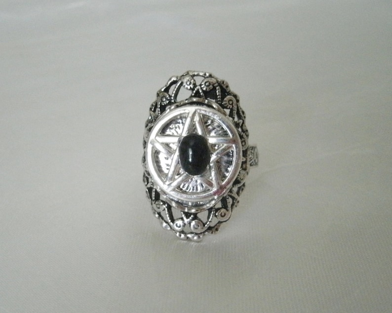 Puede incluir: Anillo de plata con una piedra negra engastada en un dise&ntilde;o de pentagrama.