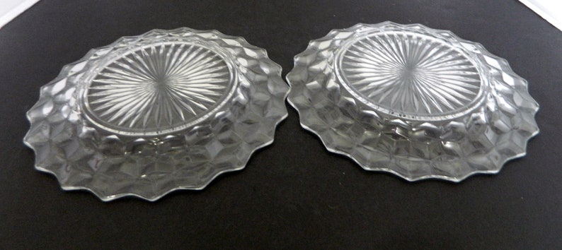 K&ouml;nnte beinhalten: Zwei klare Glasschalen mit einem Diamantmuster an den R&auml;ndern und einem radialen Design in der Mitte. Die Schalen haben einen gewellten Rand und sind oval geformt. Die Schalen bestehen aus klarem Glas.