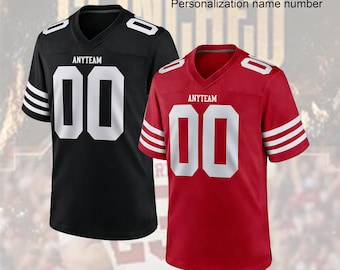 Pode incluir: Duas camisolas de futebol personalizadas, uma preta e uma vermelha, ambas com decote em V branco, riscas brancas nas mangas e o número 00 em branco no peito. O texto ANYTEAM está impresso acima do número. Texto: CUSTOM FOOTBALL JERSEY.