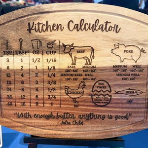 May include: Wooden kitchen calculator cutting board with engraved measurements for teaspoons, tablespoons, ounces, and cups. Includes cooking temperatures for beef, pork, chicken, and fish. Features the quote "With enough butter, anything is good."