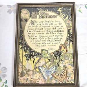 May include: Framed vintage birthday print with a decorative border. The print features a poem with floral and butterfly illustrations in shades of yellow, green, and brown. The text reads "May your Birthday bring you as its gift..."