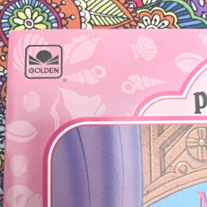 May include: Pink book cover featuring seashell illustrations and the Golden logo. The cover has a white border and a purple section. The background is a colourful floral pattern.