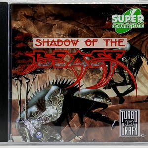 May include: A CD-ROM case for the video game "Shadow of the Beast." The cover art features a red and black graphic of a beast with the game title in red. The case also has the "TurboGrafx 16" logo.