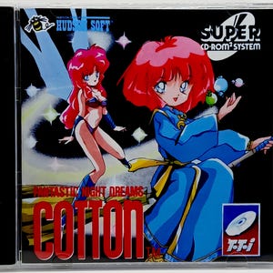 May include: A Super CD-ROM² System game case featuring the game "Cotton: Fantastic Night Dreams." The cover art showcases two anime-style female characters with red hair, set against a black background with stars and the game's title in red.