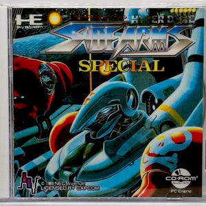 May include: A CD-ROM case featuring the game "Side Arms Special." The cover art showcases futuristic robots in shades of blue, red, and orange, with the game's title in a metallic font. The case includes the text "CD-ROM² System" and "PC Engine."