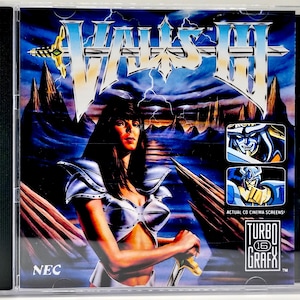 May include: A CD case for the video game, Valis III, featuring a fantasy illustration. The cover art depicts a woman in silver armor holding a sword, with a stormy sky and mountain range backdrop. The TurboGrafx-16 logo is visible.