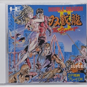 May include: A video game cartridge for the PC Engine console. The game is Double Dragon II: The Revenge. The cover art features a colorful illustration of the game's characters, including a woman in a red dress and two men in blue and purple shirts. The game's title is written in Japanese and English. The cartridge is made by Naxat Soft.