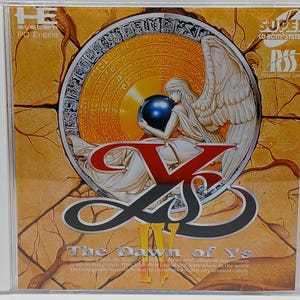 May include: A CD case featuring the game "Ys III: The Dawn of Ys." The cover art depicts a winged figure holding a blue orb, set against a detailed, golden background. The game's title is prominently displayed in red and yellow. The case also includes the "PC Engine" and "Super CD-ROM System" logos.