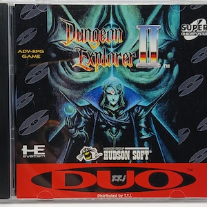 May include: A CD case for the Super CD-ROM System video game Dungeon Explorer II. The case features a black and white illustration of a character with a blue cape and a red gem in their hand. The text "Dungeon Explorer II" is written in a stylized font with a red "II". The text "HUDSON SOFT" is written in white on a black background. The text "DUO T.T.I." is written in white on a red background.