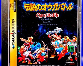 Puede incluir: Caja de juego SEGA Saturn para "Ogre Battle" con ilustraciones de fantasía coloridas. La portada muestra el título del juego en inglés y japonés, junto con ilustraciones de personajes. La caja está en una caja de plástico transparente.