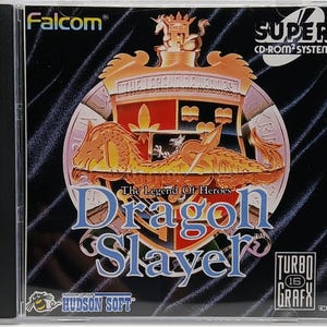 May include: A Super CD-ROM² System game cartridge for Dragon Slayer: The Legend of Heroes. The cartridge is black with a gold and red crest featuring a dragon and the game title. The text "TURBO 16 GRAFX" is in a white box on the bottom right corner.