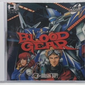 May include: A video game cover for Blood Gear, a Super CD-ROM System game for the PC Engine. The cover features a blue and red robot, a woman with red hair, and a man with brown hair. The title of the game is written in red and white letters.