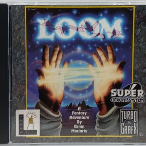 May include: A CD-ROM case for the video game "Loom." The cover art features two hands with glowing lines between them, the word "LOOM" in a blue, glowing font, and the text "A Fantasy Adventure By Brian Moriarty."