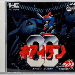 May include: A PC Engine CD-ROM game case featuring a large robot with a blue and red color scheme. The title "キアイダン ダブルオー" is prominently displayed in red and white. The case also includes the "SUPER CD-ROM SYSTEM" logo.