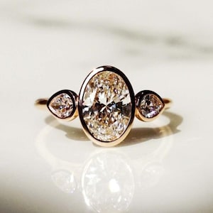 3 Stein Oval Moissanit Verlobungsring, Tropfen Seitensteine, 14K Rose Gold Lünette Ring, Einzigartiger moderner Brautschmuck, Trio Diamant Ring
