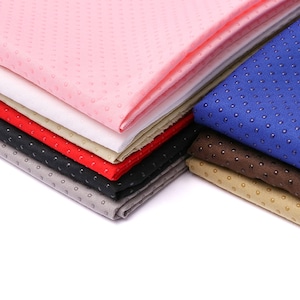May include: A stack of various colored fabrics with a dotted texture. Colors include pink, white, red, black, gray, blue, brown, and tan. The fabrics are folded and stacked, showcasing the different colors and textures.