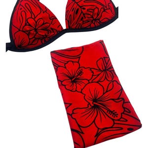 May include: A two-piece swimsuit set featuring a red bikini top with black trim and black crisscross straps, paired with a matching red rectangular fabric piece. Both items display a black floral and leaf pattern. A logo reads uniquely escario llc.