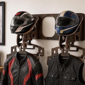 May include: A wooden motorcycle helmet and jacket rack. The rack holds two helmets, one black with red and white accents, and one blue with gold stripes. Two black leather jackets with red accents hang below the helmets.