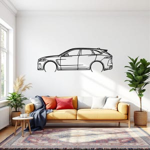 May include: A black line drawing of a modern SUV mounted on a white wall. The car's outline is detailed, showing the body, wheels, and windows. The artwork is displayed above a yellow sofa with colorful pillows and a patterned rug.