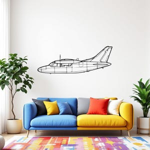 May include: A black and white line drawing of a small airplane on a white wall above a blue and yellow couch with colorful throw pillows.