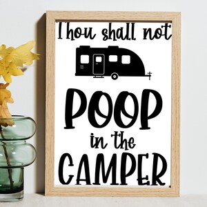 May include: A framed print with the text "Thou shall not poop in the camper." The text is in black, with a black camper graphic above the word "poop". The frame is a light brown color.