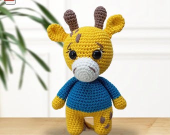 May include: A crocheted giraffe toy in yellow, blue, and brown. The giraffe has large black eyes, a white muzzle, and small brown horns. The text "Crochet pattern" is at the top of the image. A PDF icon is in the upper left corner.