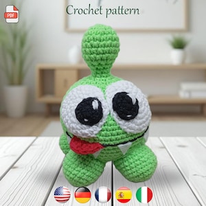 May include: A green crocheted monster with large white-rimmed eyes, black pupils, and a red tongue. The monster has small white teeth and a bulbous head. The words "Crochet pattern" are above the monster.