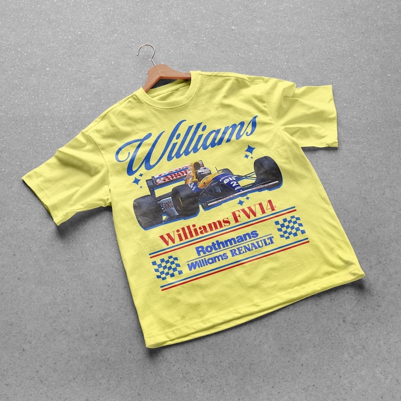 May include: A yellow t-shirt featuring a vintage Williams FW14 race car design. The shirt has the word "Williams" in blue script across the top, with the car graphic below. The text "Rothmans Williams Renault" is also visible.