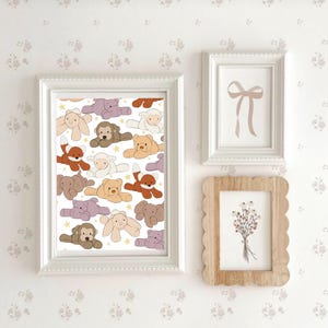 May include: A white framed print with a white background and a pattern of colorful stuffed animals. The animals include a fox, a bear, a monkey, a lamb, a hippopotamus, and a bunny. The print is surrounded by a white wall with a floral pattern.
