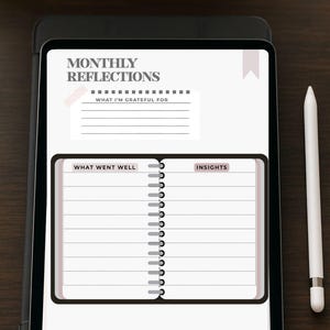 May include: A digital tablet displaying a monthly reflection journal page. The journal includes prompts for gratitude, what went well, and insights. A white stylus rests beside the tablet on a dark wooden surface.