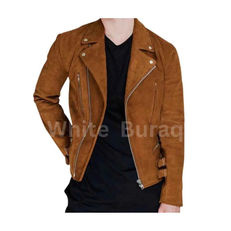 May include: A brown suede biker jacket with a notched collar, asymmetrical zipper closure, and multiple zippered pockets. The jacket features silver hardware and buckle details at the waist. The text "White Buraq" is visible on the jacket.