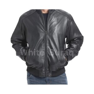 May include: A black leather bomber jacket with a zipper closure and ribbed cuffs and hem. The jacket has two front pockets and a classic bomber style. The text "White Buraq" is visible on the lower part of the jacket.