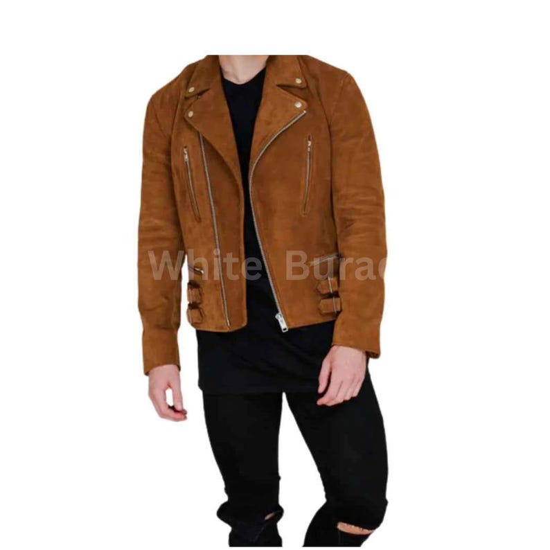 May include: A brown suede jacket with a classic biker style. The jacket features a notched collar, asymmetrical zipper, multiple zippered pockets, and buckle details at the waist and cuffs. The text "White Bura" is visible on the jacket.
