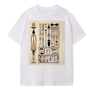May include: White t-shirt featuring a beige square graphic with black and gold Egyptian hieroglyphs. The graphic includes various symbols and figures, creating a historical and artistic design. The shirt is a casual wear item.