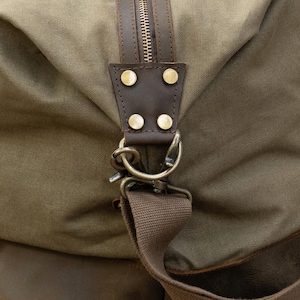 close up of buckle on the green langston duffle bag