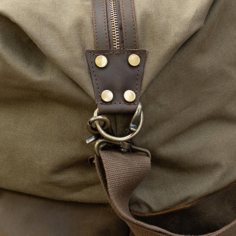 close up of buckle on the green langston duffle bag